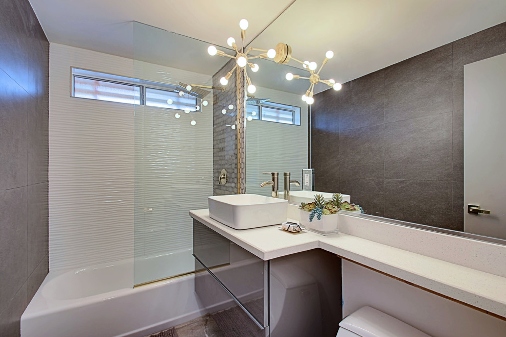 Стильный дизайн: маленькая ванная комната в стиле ретро с плоскими фасадами, серыми фасадами, ванной в нише, душем над ванной, унитазом-моноблоком, белой плиткой, керамогранитной плиткой, бетонным полом, душевой кабиной, настольной раковиной, столешницей из искусственного кварца и коричневыми стенами для на участке и в саду - последний тренд