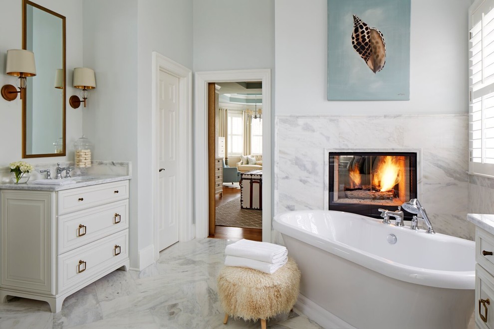 アトランタにある広いトランジショナルスタイルのおしゃれなマスターバスルーム (白いキャビネット、置き型浴槽、グレーの壁、レイズドパネル扉のキャビネット) の写真