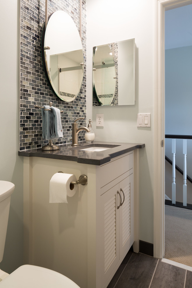 Inredning av ett modernt litet badrum med dusch, med luckor med lamellpanel, vita skåp, en toalettstol med hel cisternkåpa, svart och vit kakel, keramikplattor, vita väggar, mörkt trägolv, ett nedsänkt handfat och marmorbänkskiva