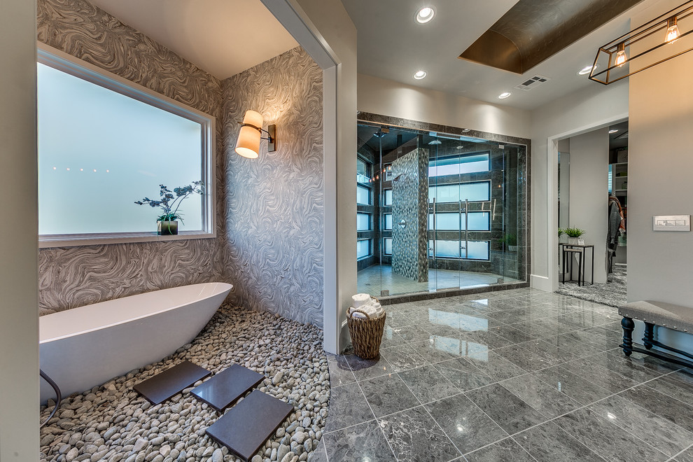 Foto de cuarto de baño principal contemporáneo con bañera exenta, ducha doble y paredes grises