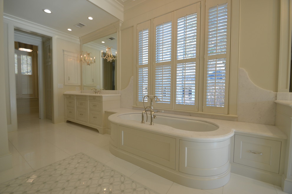 Large transitional master beige tile and white tile marble floor bathroom photo in Atlanta with shaker cabinets, white cabinets, an undermount tub, a two-piece toilet, beige walls, an undermount sink and quartz countertops