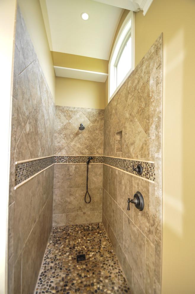 Idéer för ett stort klassiskt en-suite badrum, med luckor med upphöjd panel, skåp i slitet trä, en dusch i en alkov, beige kakel, keramikplattor, beige väggar, klinkergolv i småsten, ett undermonterad handfat, granitbänkskiva, ett fristående badkar, beiget golv och dusch med gångjärnsdörr