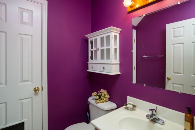На фото: маленькая ванная комната в стиле неоклассика (современная классика) с монолитной раковиной, унитазом-моноблоком, фиолетовыми стенами и светлым паркетным полом для на участке и в саду