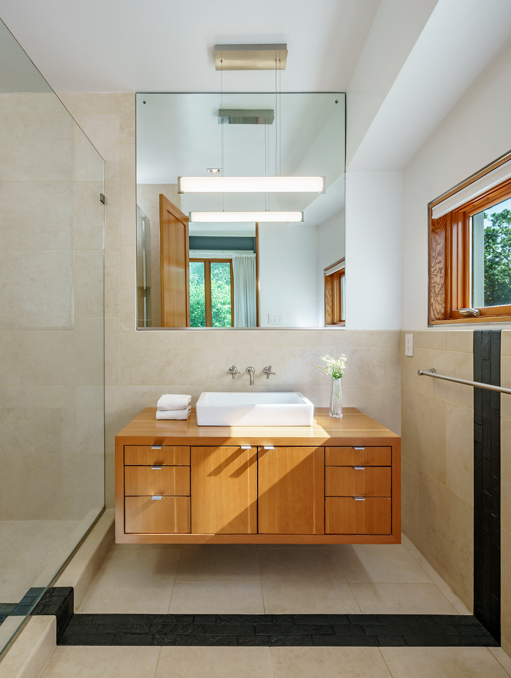 Foto på ett litet industriellt badrum med dusch, med skåp i mellenmörkt trä, beige kakel, porslinskakel, vita väggar, klinkergolv i porslin, ett fristående handfat, träbänkskiva och flerfärgat golv