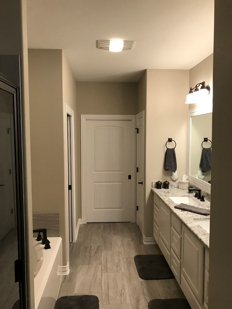 Example of a small classic master gray tile and porcelain tile porcelain tile bathroom design in Austin with raised-panel cabinets, white cabinets, a two-piece toilet, gray walls, an undermount sink and granite countertops