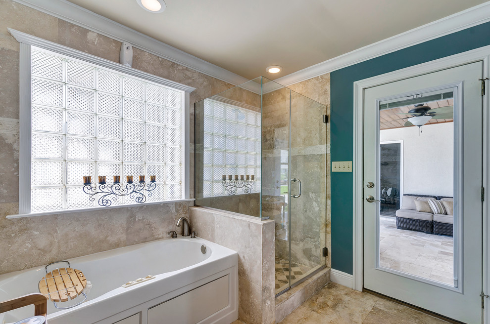 На фото: ванная комната в морском стиле с ванной в нише, угловым душем и бежевой плиткой с