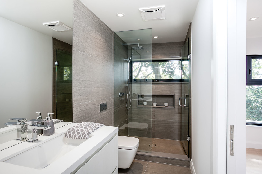 Medium sized contemporary shower room bathroom in Toronto with flat-panel cabinets, white cabinets, an alcove shower, a wall mounted toilet, grey tiles, porcelain tiles, white walls, porcelain flooring, a submerged sink, quartz worktops, grey floors, a hinged door and white worktops.