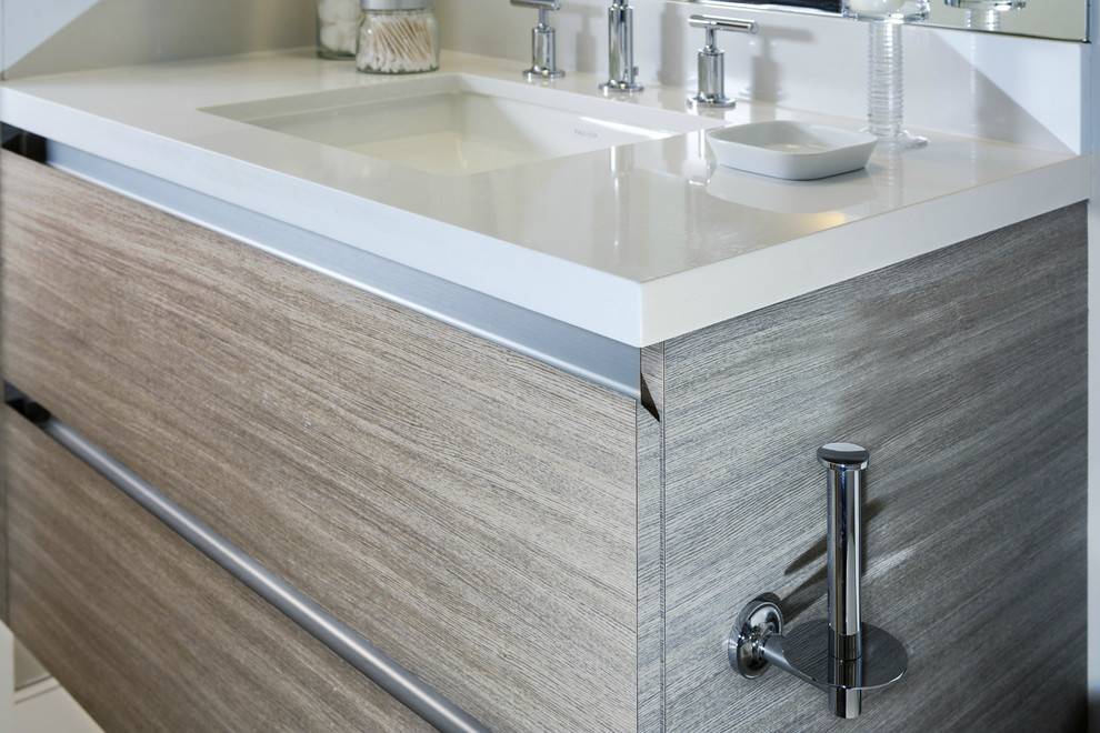 Idee per una stanza da bagno minimalista con lavabo sottopiano, ante lisce, ante grigie e top in superficie solida