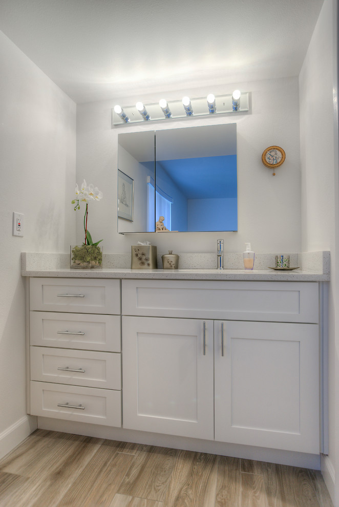 Foto de cuarto de baño principal moderno de tamaño medio con armarios estilo shaker, puertas de armario blancas, bañera empotrada, combinación de ducha y bañera, sanitario de una pieza, baldosas y/o azulejos multicolor, paredes blancas, lavabo bajoencimera y encimera de cuarzo compacto