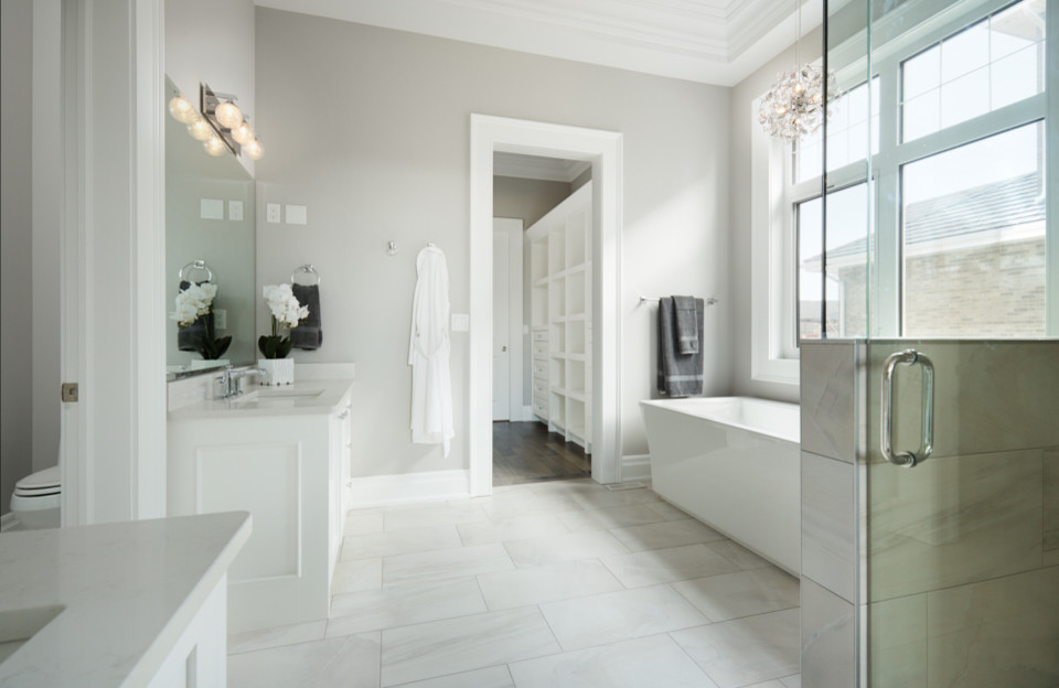 Inspiration for a medium sized classic ensuite bathroom in Edmonton with raised-panel cabinets, white cabinets, a freestanding bath, a walk-in shower, a one-piece toilet, white tiles, stone tiles, white walls, ceramic flooring, a built-in sink, soapstone worktops, white floors and an open shower.