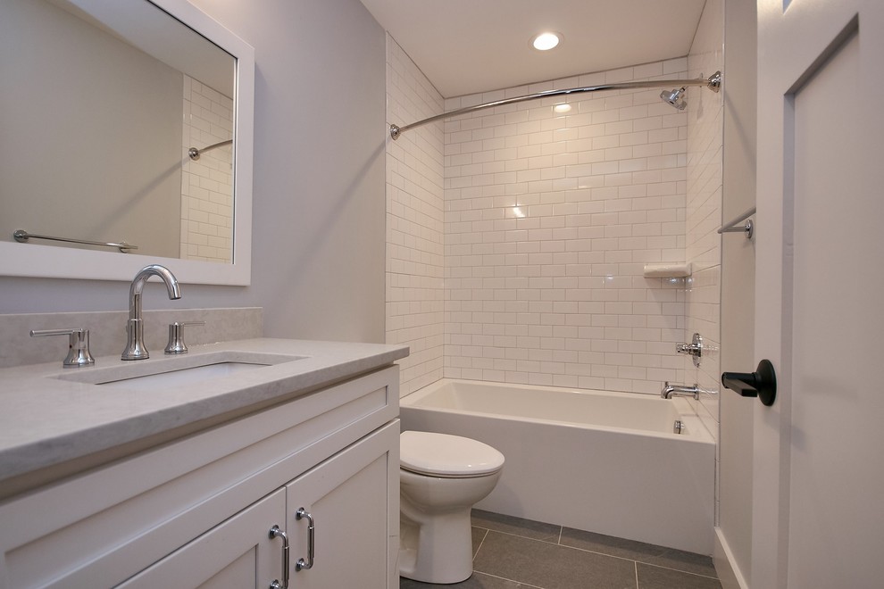 Aménagement d'une salle de bain campagne de taille moyenne avec un placard avec porte à panneau encastré, des portes de placard blanches, une baignoire en alcôve, un combiné douche/baignoire, WC séparés, un carrelage blanc, des carreaux de céramique, un mur gris, un sol en carrelage de céramique, un lavabo encastré, un plan de toilette en quartz modifié, un sol gris, une cabine de douche avec un rideau et un plan de toilette gris.