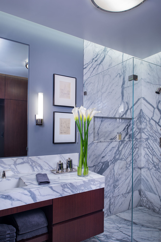 Inspiration pour une salle de bain design en bois brun de taille moyenne avec un lavabo encastré, un placard à porte plane, un plan de toilette en marbre, une douche d'angle, un mur gris et un sol en marbre.