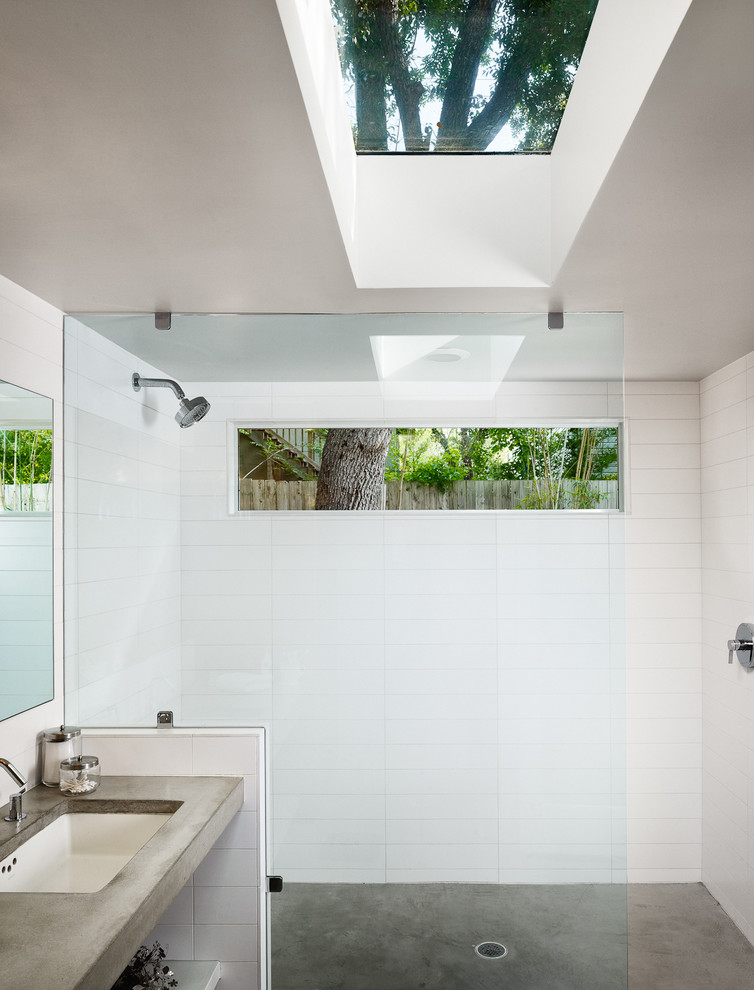 Cette photo montre une salle de bain tendance avec un plan de toilette en béton, sol en béton ciré et une fenêtre.