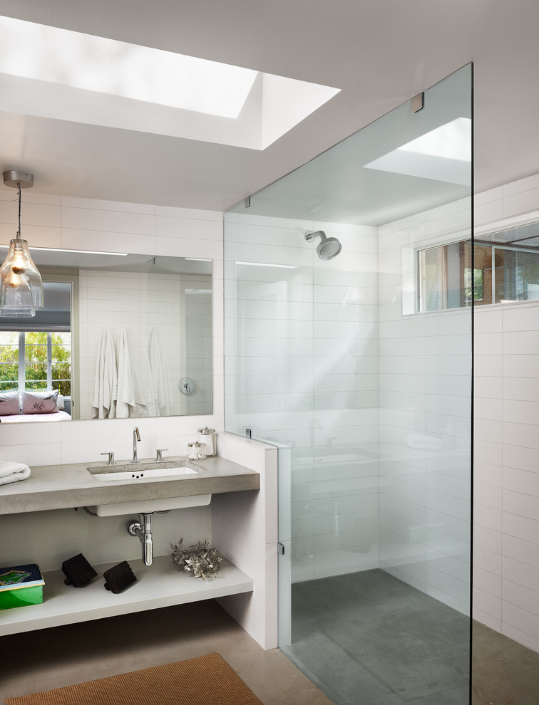 Cette image montre une salle de bain design avec un plan de toilette en béton et sol en béton ciré.