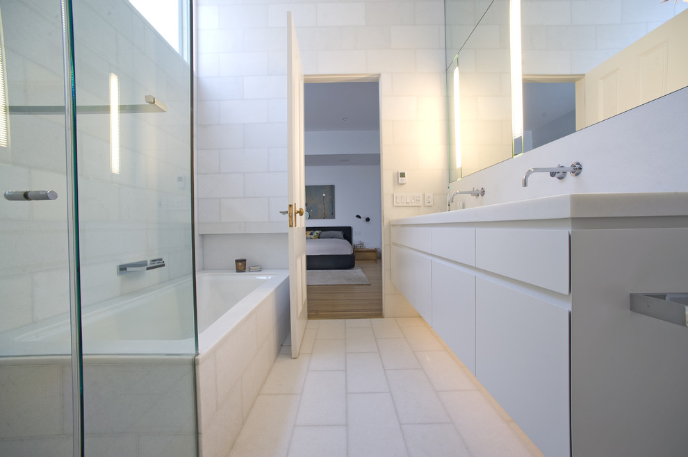 Idéer för ett modernt badrum, med släta luckor, vita skåp, ett badkar i en alkov, vit kakel och vitt golv