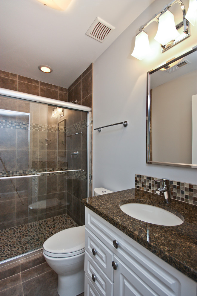 Exemple d'une salle d'eau tendance avec des portes de placard blanches, une douche d'angle, WC à poser, un mur beige, un sol en carrelage de céramique, un lavabo intégré et un plan de toilette en granite.