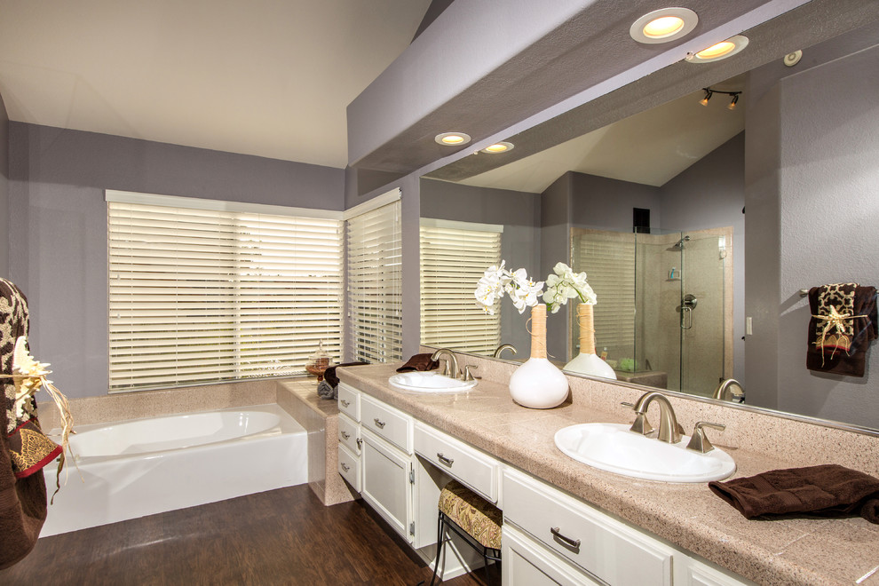 サンディエゴにあるラグジュアリーなトランジショナルスタイルのおしゃれな浴室 (落し込みパネル扉のキャビネット、御影石の洗面台、ドロップイン型浴槽、アルコーブ型シャワー、濃色無垢フローリング) の写真