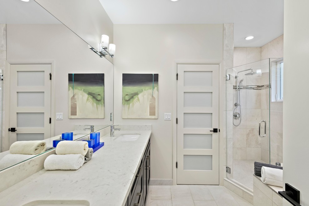 Example of a transitional master white tile white floor corner shower design in San Francisco with shaker cabinets, black cabinets, white walls, an undermount sink, a hinged shower door and gray countertops