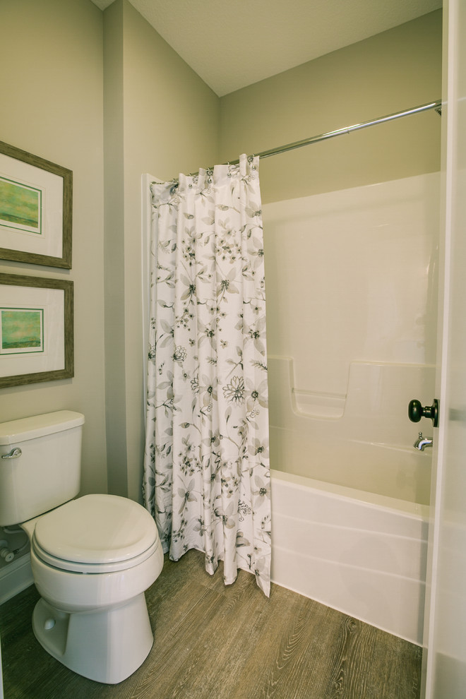 Bild på ett litet vintage badrum med dusch, med vita skåp, ett badkar i en alkov, en dusch/badkar-kombination, beige väggar, mellanmörkt trägolv, ett integrerad handfat, bänkskiva i kvarts, brunt golv, en toalettstol med separat cisternkåpa och dusch med duschdraperi