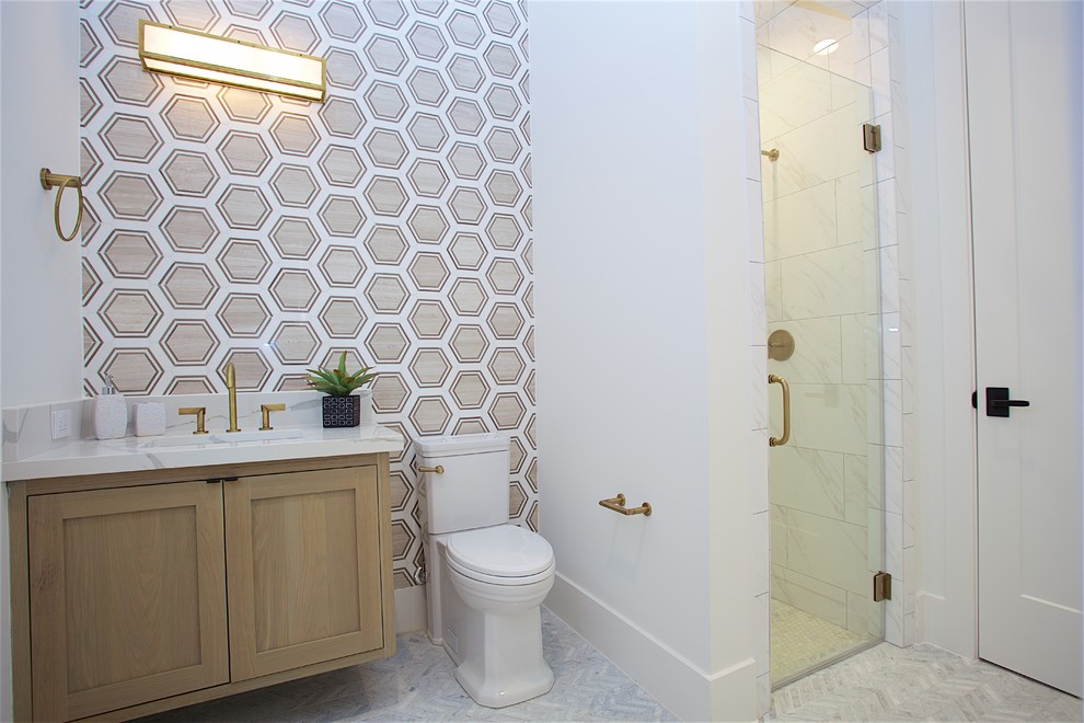 Inspiration for a small contemporary master white tile and marble tile marble floor and white floor alcove shower remodel in Houston with recessed-panel cabinets, light wood cabinets, a two-piece toilet, white walls, an undermount sink, quartz countertops, a hinged shower door and white countertops