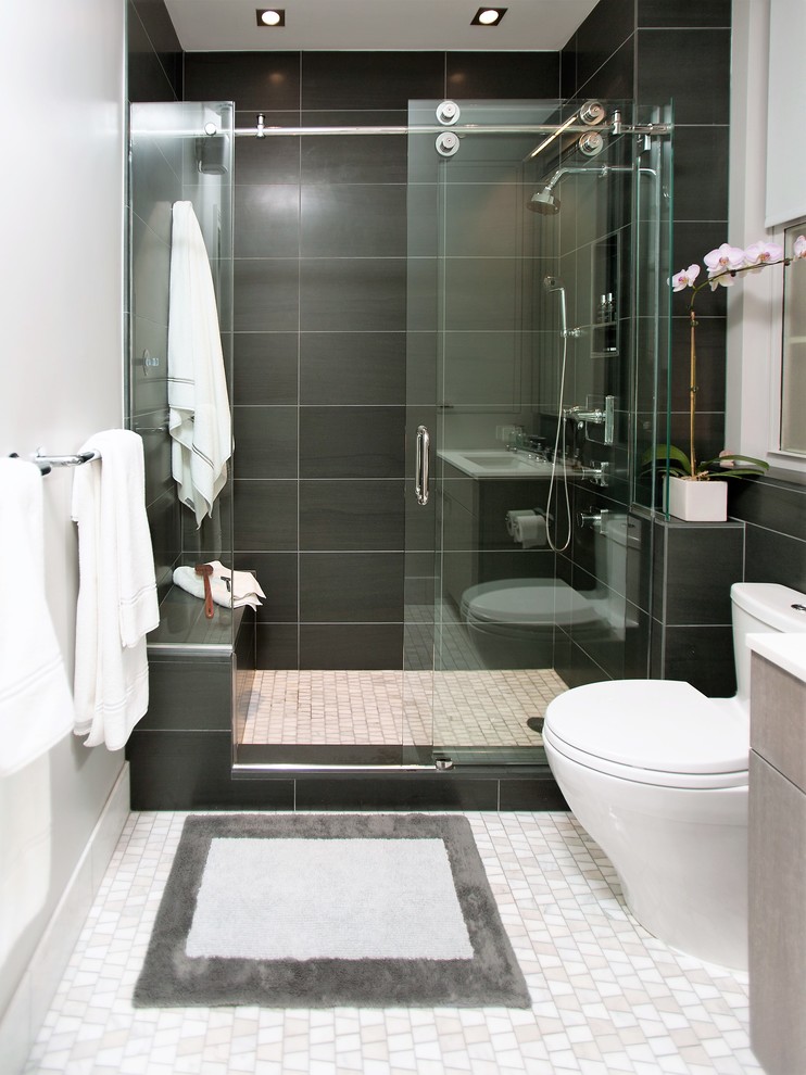 Kleines Modernes Badezimmer En Suite mit flächenbündigen Schrankfronten, grauen Schränken, Duschnische, Toilette mit Aufsatzspülkasten, Steinfliesen, weißer Wandfarbe, Marmorboden, Unterbauwaschbecken und Mineralwerkstoff-Waschtisch in Sonstige