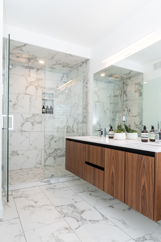 Design ideas for a contemporary ensuite bathroom in Other with flat-panel cabinets, dark wood cabinets, an alcove shower, grey tiles, white tiles, white walls, a submerged sink, grey floors, a hinged door and white worktops.