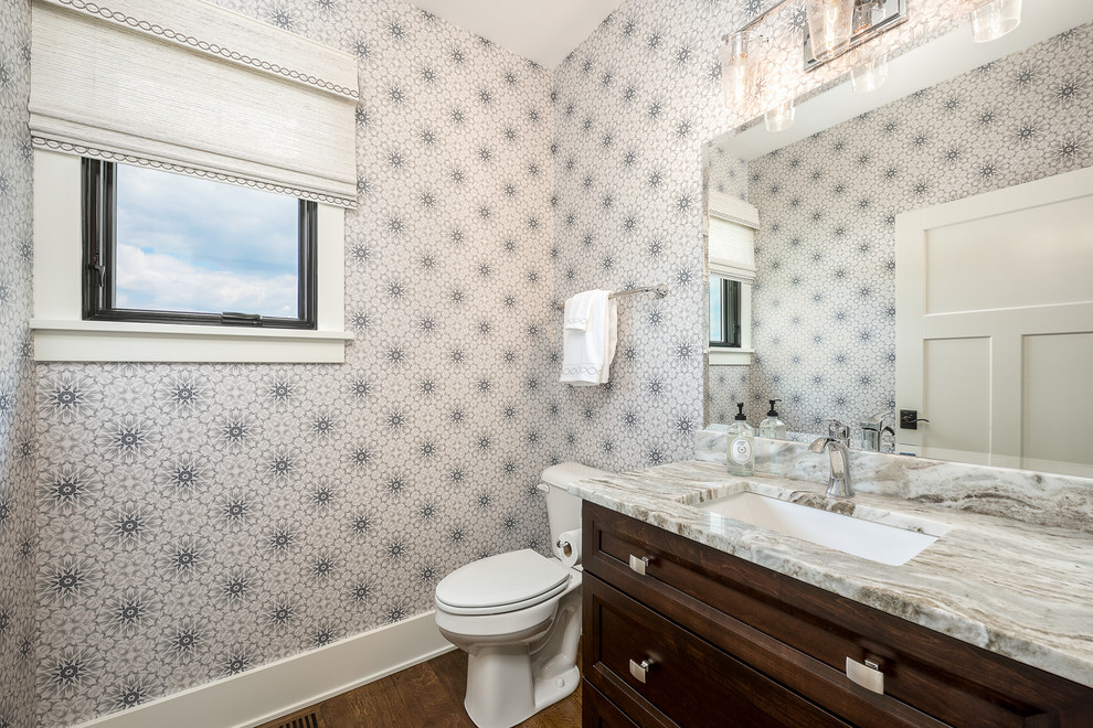 Bild på ett litet funkis badrum med dusch, med luckor med upphöjd panel, bruna skåp, en toalettstol med separat cisternkåpa, blå väggar, mörkt trägolv, ett integrerad handfat, marmorbänkskiva och brunt golv