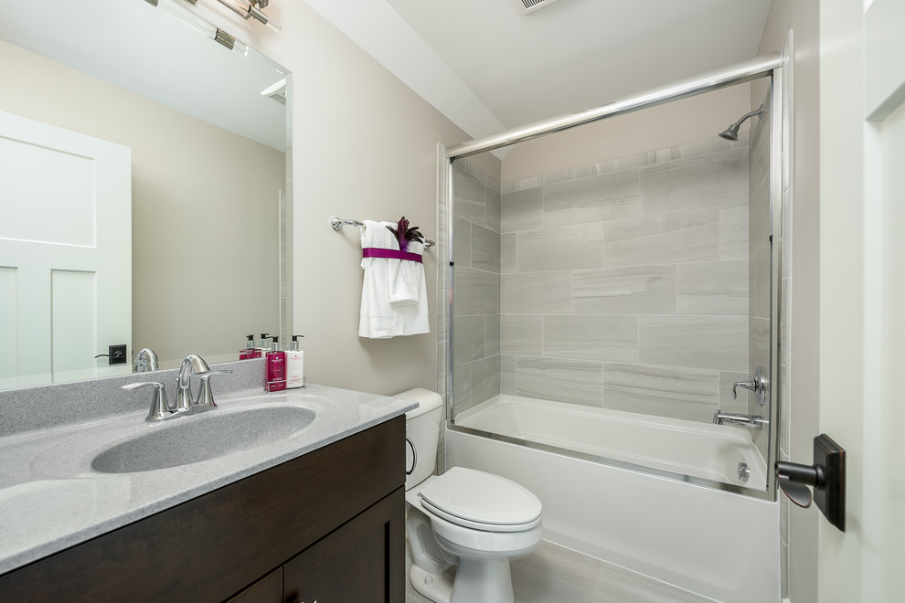 Exempel på ett mellanstort modernt badrum med dusch, med luckor med upphöjd panel, skåp i mörkt trä, ett badkar i en alkov, en dusch/badkar-kombination, en toalettstol med separat cisternkåpa, beige kakel, keramikplattor, beige väggar, klinkergolv i keramik, ett integrerad handfat, laminatbänkskiva, beiget golv och dusch med skjutdörr