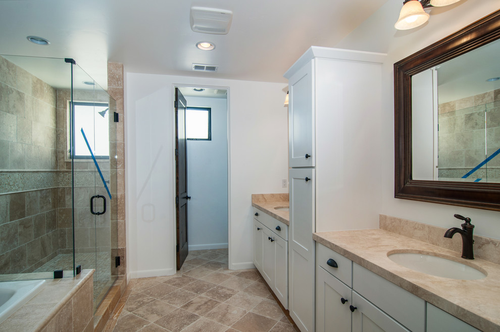 Example of a large tuscan master brown tile and stone tile travertine floor double shower design in San Diego with an undermount sink, white cabinets and white walls