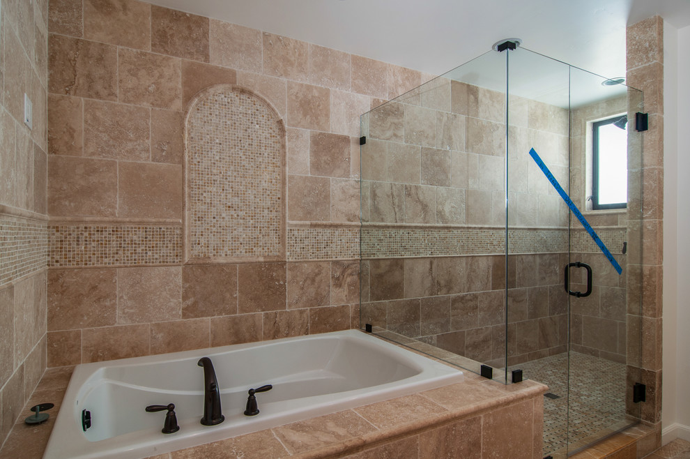 Large tuscan master brown tile and stone tile travertine floor double shower photo in San Diego with an undermount sink, white cabinets and white walls