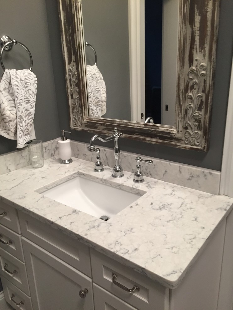 Imagen de cuarto de baño rústico con lavabo bajoencimera, puertas de armario blancas, encimera de cuarzo compacto y paredes grises