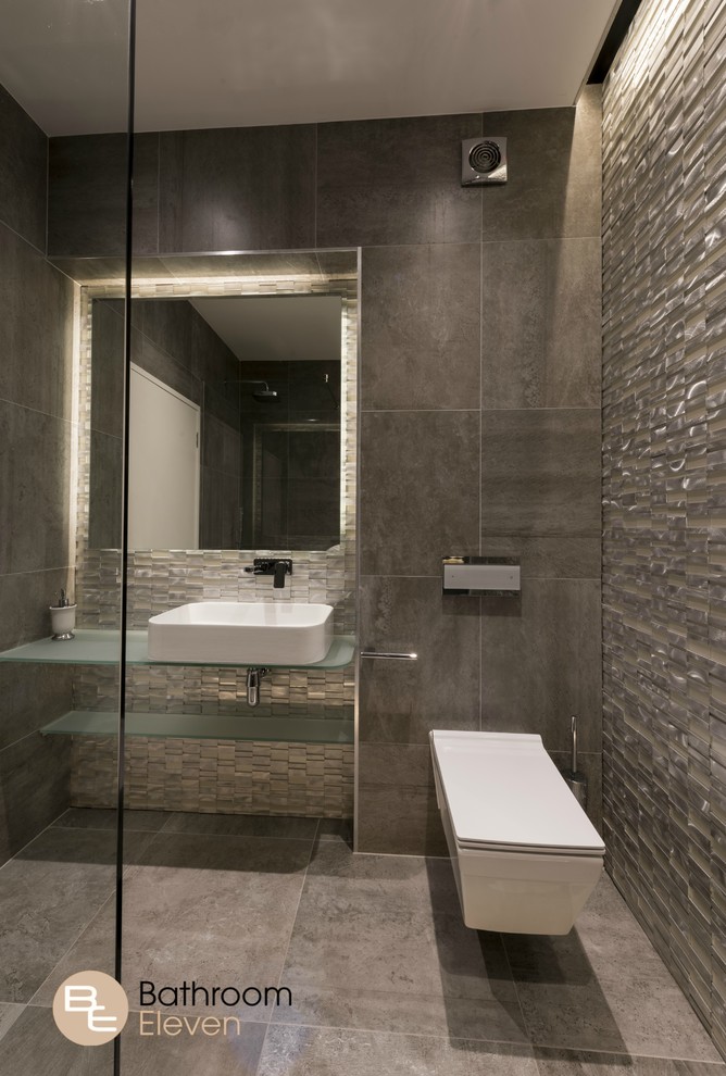 Idee per una stanza da bagno minimal con doccia aperta, WC sospeso, piastrelle marroni, piastrelle a mosaico, pareti marroni, pavimento con piastrelle in ceramica, lavabo rettangolare e top in vetro