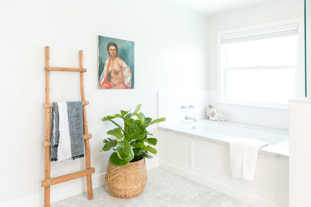 Maritim inredning av ett en-suite badrum, med skåp i shakerstil, vita skåp, ett undermonterat badkar, en hörndusch, vit kakel, tunnelbanekakel, vita väggar, marmorgolv, ett undermonterad handfat och marmorbänkskiva