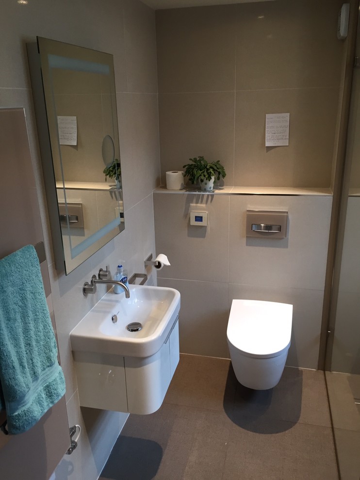 Design ideas for a medium sized contemporary shower room bathroom in Dorset with white cabinets, a walk-in shower, a wall mounted toilet, beige tiles, porcelain tiles, beige walls, porcelain flooring and a wall-mounted sink.