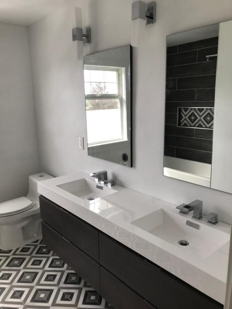 Large minimalist master ceramic tile cement tile floor bathroom photo in Seattle with recessed-panel cabinets, dark wood cabinets, white walls, an integrated sink, quartzite countertops, a hinged shower door and white countertops