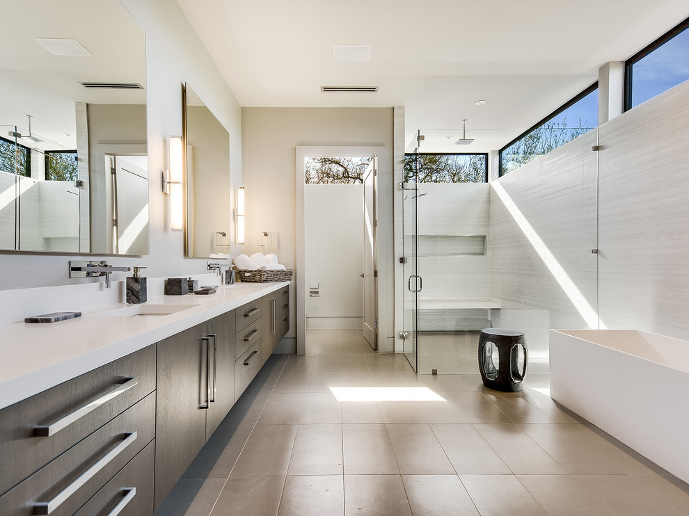 Exemple d'une salle de bain principale tendance en bois foncé avec un placard à porte plane, une baignoire indépendante, un espace douche bain, un carrelage gris, un lavabo encastré, un sol beige, une cabine de douche à porte battante, un plan de toilette blanc et des toilettes cachées.
