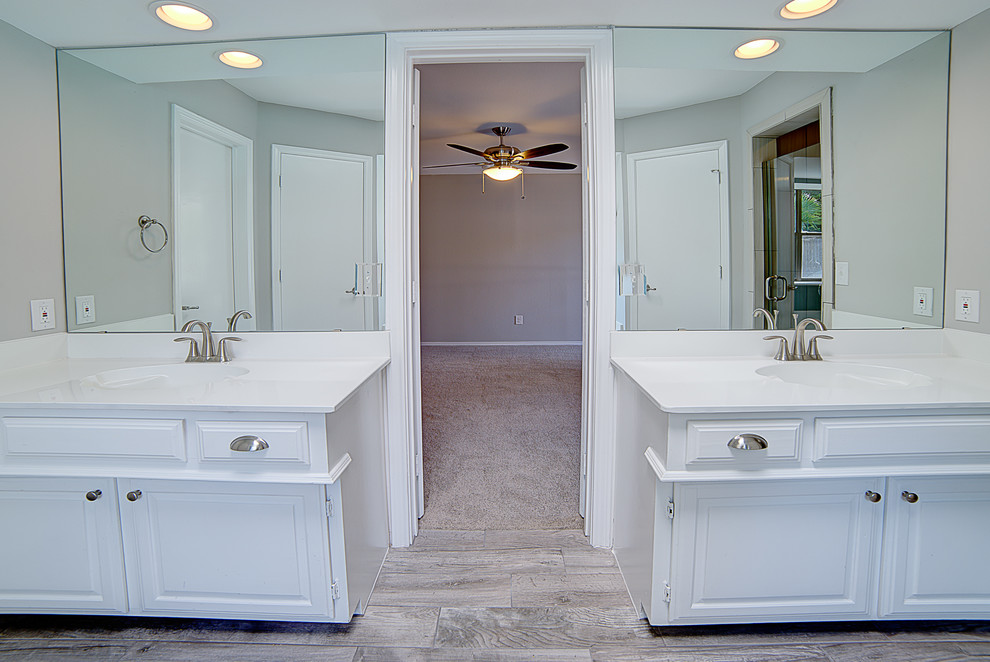 Klassisk inredning av ett stort en-suite badrum, med luckor med upphöjd panel, vita skåp, ett platsbyggt badkar, klinkergolv i keramik och marmorbänkskiva