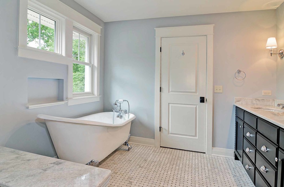 Aménagement d'une salle de bain principale classique en bois foncé de taille moyenne avec une baignoire sur pieds, WC à poser et un mur bleu.