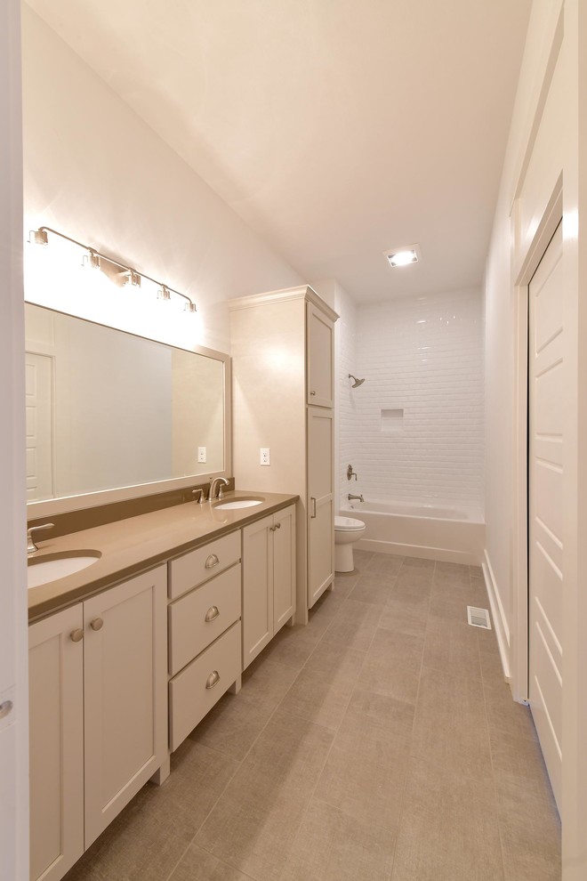 Classic family bathroom with recessed-panel cabinets, white cabinets, an alcove bath, a shower/bath combination, white walls, a submerged sink, grey floors, a shower curtain, brown worktops, double sinks, a built in vanity unit, a two-piece toilet and a wall niche.