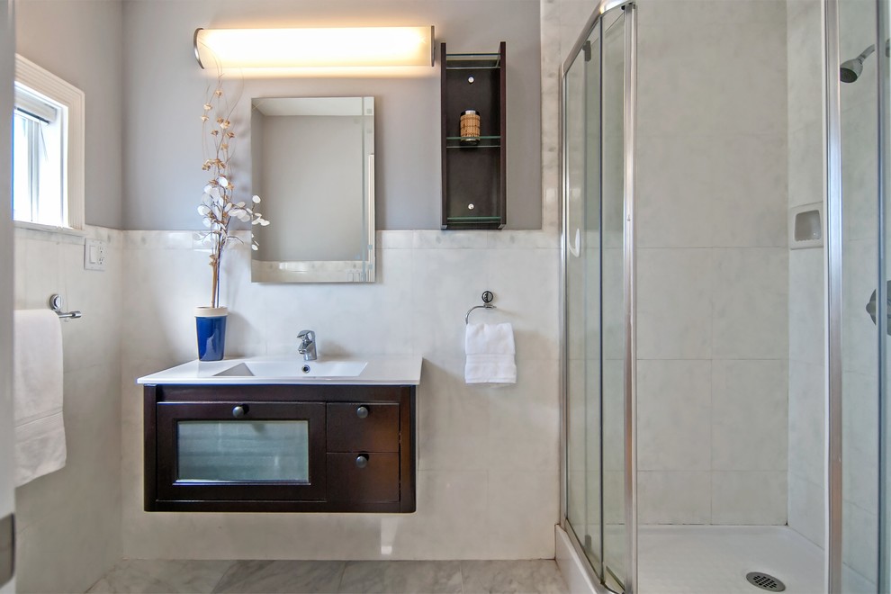 На фото: маленькая ванная комната в стиле неоклассика (современная классика) с душевой кабиной, стеклянными фасадами, темными деревянными фасадами, столешницей из гранита, белой плиткой и каменной плиткой для на участке и в саду с