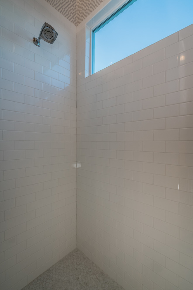 Imagen de cuarto de baño principal de estilo de casa de campo pequeño con paredes beige, suelo de cemento, puertas de armario azules, bañera encastrada, ducha abierta, baldosas y/o azulejos blancos, lavabo encastrado y encimera de granito