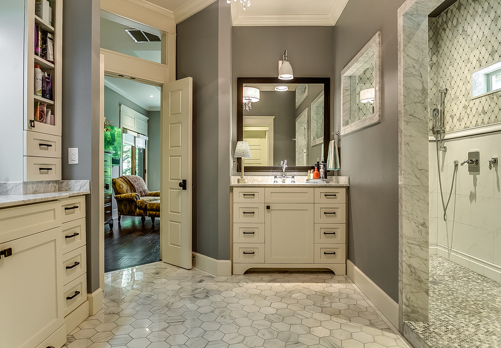 This is an example of a large traditional ensuite bathroom in Dallas with shaker cabinets, white cabinets, a walk-in shower, a one-piece toilet, grey tiles, porcelain tiles, grey walls, marble flooring, a submerged sink and marble worktops.