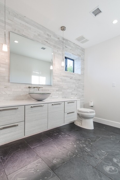 Example of a mid-sized master multicolored tile and stone tile slate floor bathroom design in Phoenix with an undermount sink, flat-panel cabinets, light wood cabinets, quartz countertops, a one-piece toilet and white walls