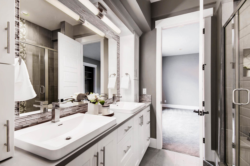 Idéer för ett mellanstort modernt grå en-suite badrum, med skåp i shakerstil, vita skåp, en hörndusch, grå kakel, kakel i metall, grå väggar, klinkergolv i porslin, ett fristående handfat, bänkskiva i akrylsten, grått golv och dusch med gångjärnsdörr