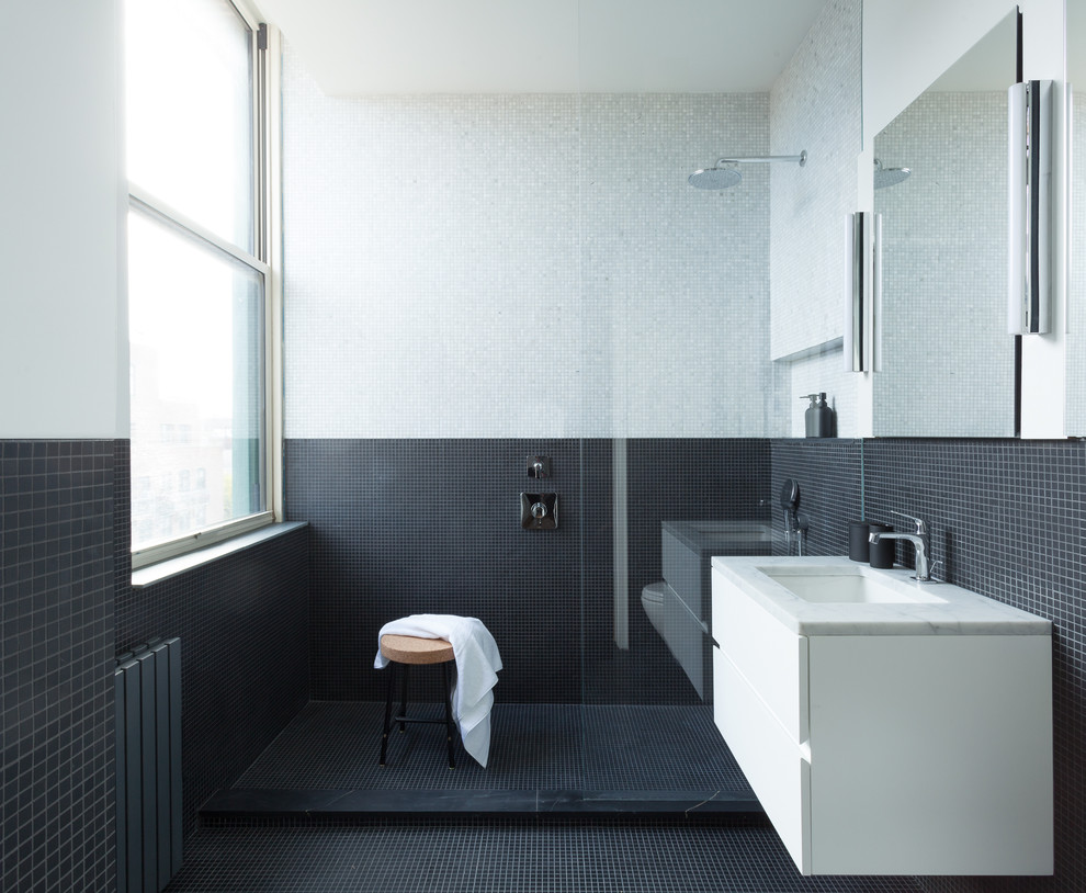 Стильный дизайн: главная ванная комната среднего размера в стиле модернизм с плоскими фасадами, белыми фасадами, душем в нише, черной плиткой, серой плиткой, плиткой мозаикой, разноцветными стенами, полом из мозаичной плитки, врезной раковиной, мраморной столешницей, черным полом, открытым душем и серой столешницей - последний тренд