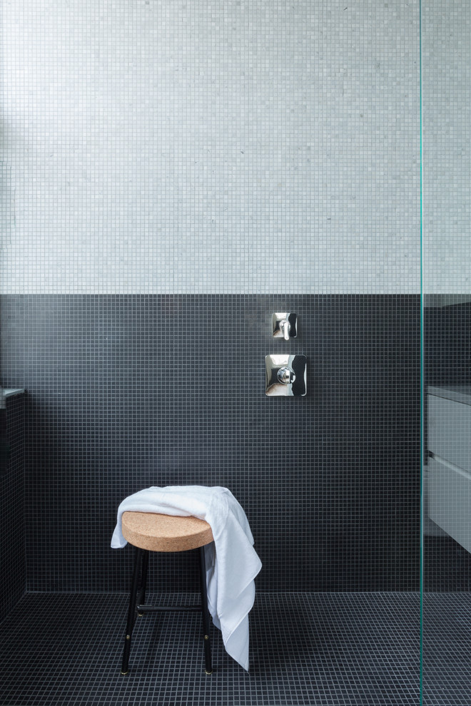 This is an example of a medium sized contemporary ensuite bathroom in New York with flat-panel cabinets, white cabinets, an alcove shower, black tiles, grey tiles, mosaic tiles, multi-coloured walls, mosaic tile flooring, a submerged sink, marble worktops and black floors.