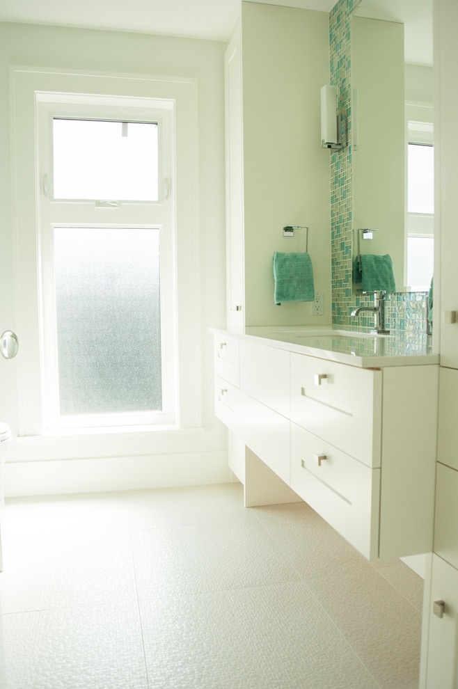 Aménagement d'une salle de bain classique pour enfant avec un placard à porte shaker, des portes de placard blanches, un carrelage bleu, un carrelage en pâte de verre et un plan de toilette en quartz modifié.