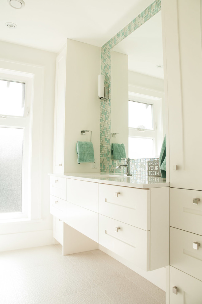 Exemple d'une salle de bain chic pour enfant avec un placard à porte shaker, des portes de placard blanches, un carrelage vert, un carrelage en pâte de verre, un mur blanc et un lavabo encastré.