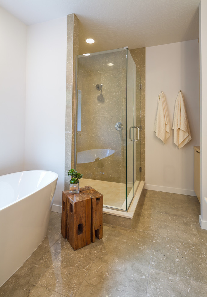 Mid-sized 1950s master green tile and stone tile limestone floor freestanding bathtub photo in Other with flat-panel cabinets, light wood cabinets, a two-piece toilet, white walls, an undermount sink and limestone countertops
