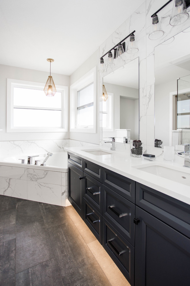 Foto på ett vintage vit en-suite badrum, med luckor med infälld panel, svarta skåp, ett hörnbadkar, vit kakel, marmorkakel, vita väggar, ett undermonterad handfat och brunt golv